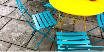 Klappcafé Das Foto zeigt blaue Stühle und einen gelben Tisch